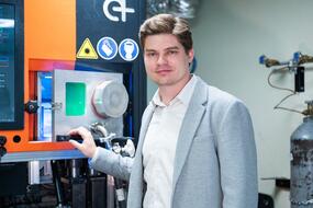 Станислав Чернышихин стоит рядом с 3D-принтером, на котором печатали электрический вольфрамовый нагреватель